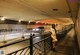 A naked woman standing on a bridge in a parking garage.