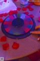 A wheel of fortune on a table surrounded by rose petals.