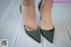 A close up of a woman's feet wearing green shoes.