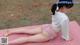 A woman is doing a yoga pose on a pink mat.