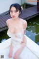 A naked asian woman sitting in a bathtub covered in foam.