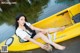 A woman sitting in a yellow kayak on the water.