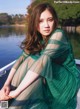 A woman in a green dress sitting on a boat.