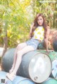 A woman sitting on top of a pile of metal barrels.