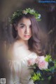 A woman in a floral dress holding a bouquet of flowers.