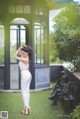 A woman standing in front of a gazebo in a park.