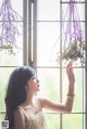 A woman in a white dress holding a bunch of flowers.