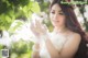 A woman in a wedding dress holding a flower in her hand.