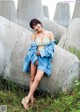 A woman sitting on top of a concrete structure.