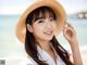 A woman wearing a straw hat on the beach.