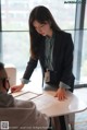 A woman in a business suit sitting at a table with a man.