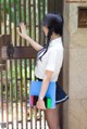 A woman in a school uniform holding a blue folder.