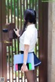 A woman standing in front of a door holding a cell phone.