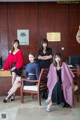 A group of women sitting on a chair in front of a desk.