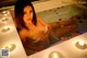 A woman sitting in a bathtub with candles in it.