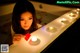 A woman in a bathtub with candles and a red heart.