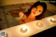 A woman laying in a bathtub with candles in it.