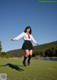 A woman in a school uniform is jumping in the air.