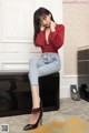 A woman sitting on top of a wooden box in a room.