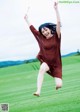 A woman in a brown dress jumping in the air.