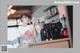 A woman standing behind a counter in a coffee shop.