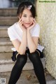 A young woman sitting on the steps of a building.